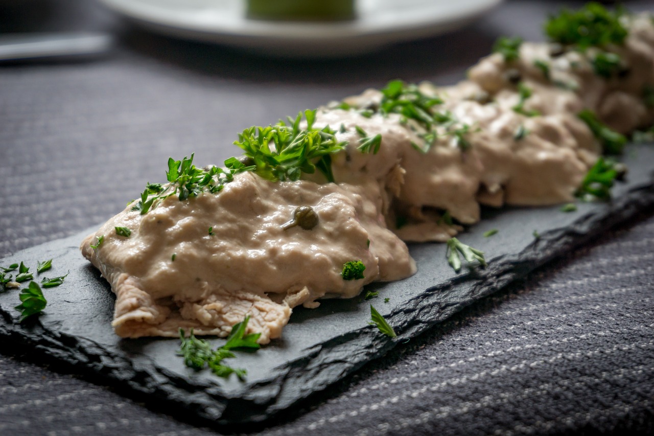 Fette di vitello tonnato guarnite con salsa tonnata e capperi, piatto tradizionale piemontese.