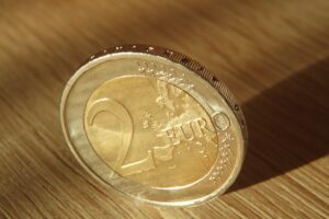 Monete da 2 euro ritirate, esposte su sfondo bianco, evidenziando il loro valore attuale.