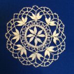 Vecchi centrini della nonna su un tavolo, simbolo di artigianato e valore nostalgico.